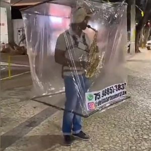 Saxofonista cria ‘cabine’ para se proteger da Covid-19 enquanto toca em ruas de Salvador