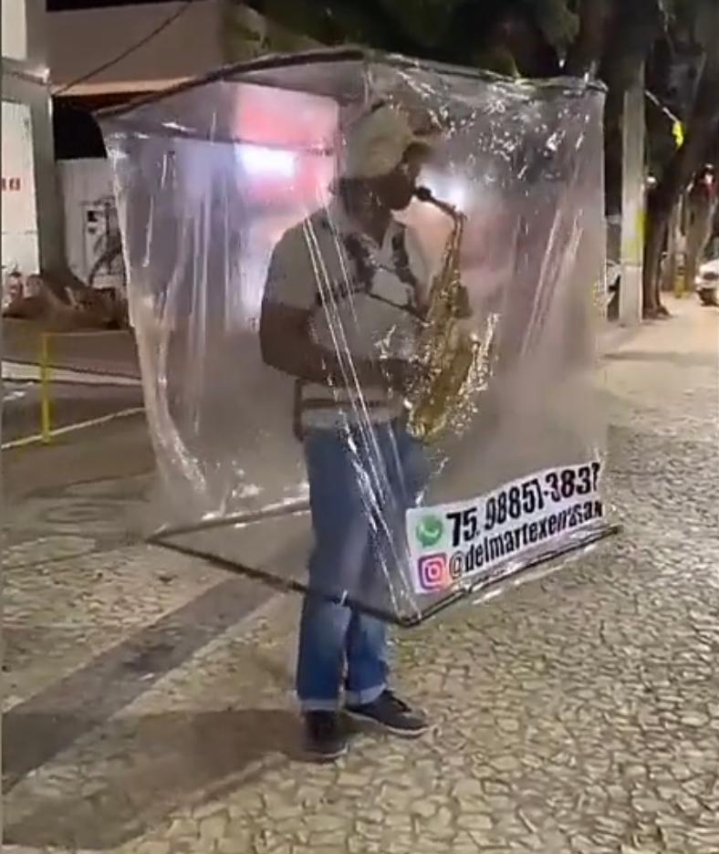 Saxofonista cria ‘cabine’ para se proteger da Covid-19 enquanto toca em ruas de Salvador